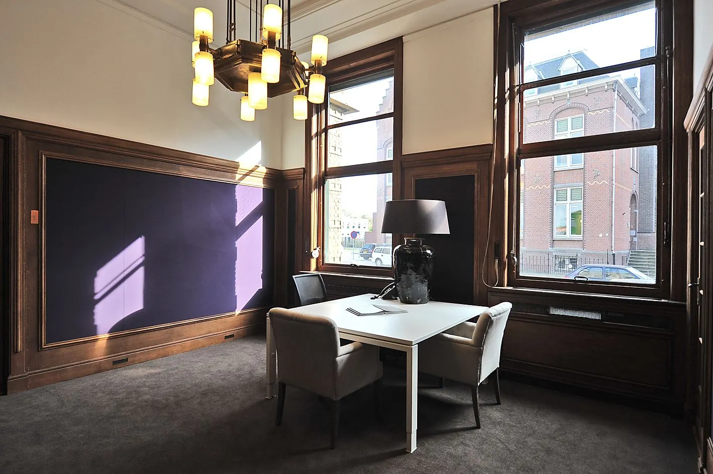 Stijlvol kantoor aan de Ceresstraat 13 met hoge ramen, houten lambrisering en een moderne vergadertafel.