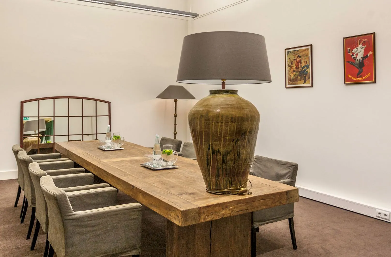 Vergaderruimte aan de Ceresstraat 13 met een robuuste houten tafel, zes stoelen, grote tafellamp en decoratieve kunst aan de muur.