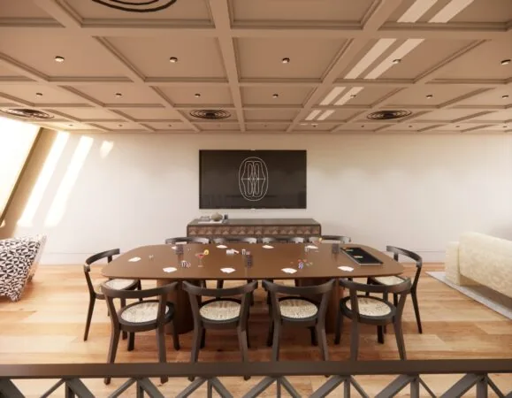 Spelruimte met een grote tafel vol pokerfiches en speelkaarten in een modern ingerichte gemeenschappelijke ruimte.