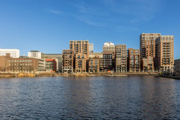 Moderne appartementengebouwen aan het water bij Coolhaven in Rotterdam onder een heldere blauwe lucht.