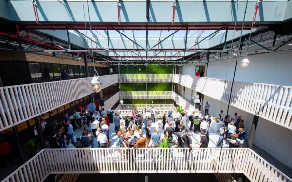 Overzichtsfoto van een drukbezocht netwerkevenement tijdens het HortiHeroes Hero Festival in een lichte, moderne binnenruimte met groenaccenten.