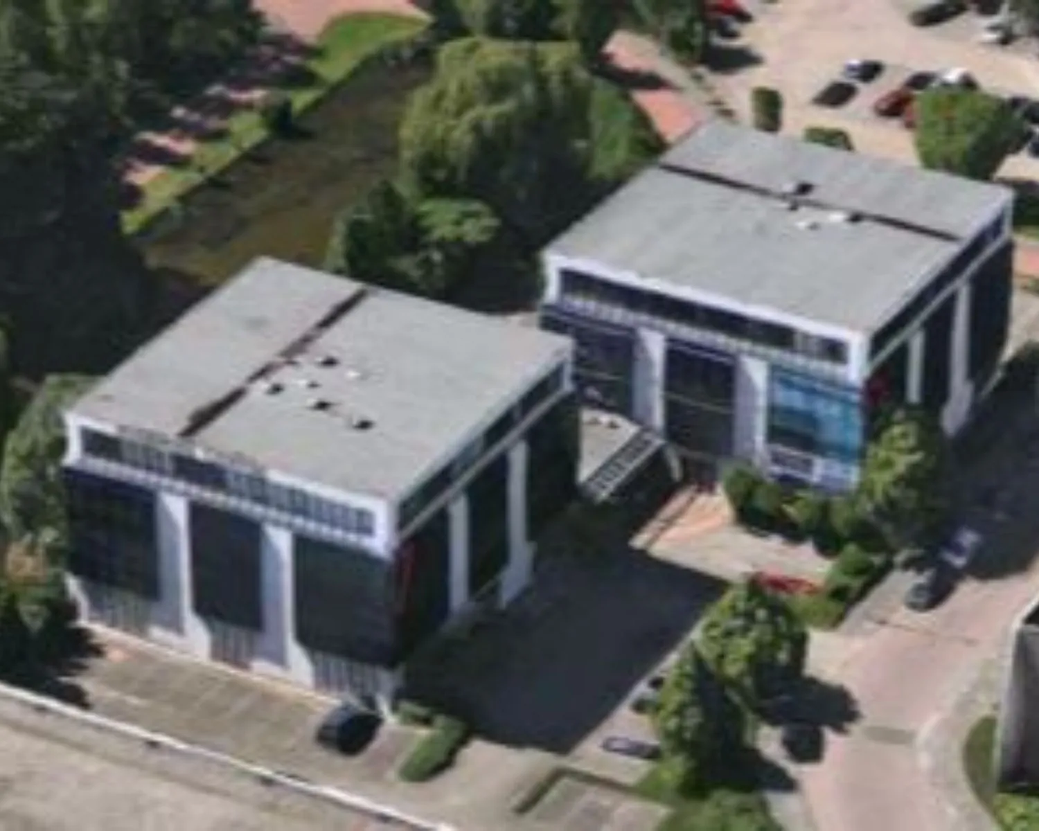 Luchtfoto van twee kantoorgebouwen aan de Cypresbaan 7-9, omgeven door groen en parkeerplaatsen.