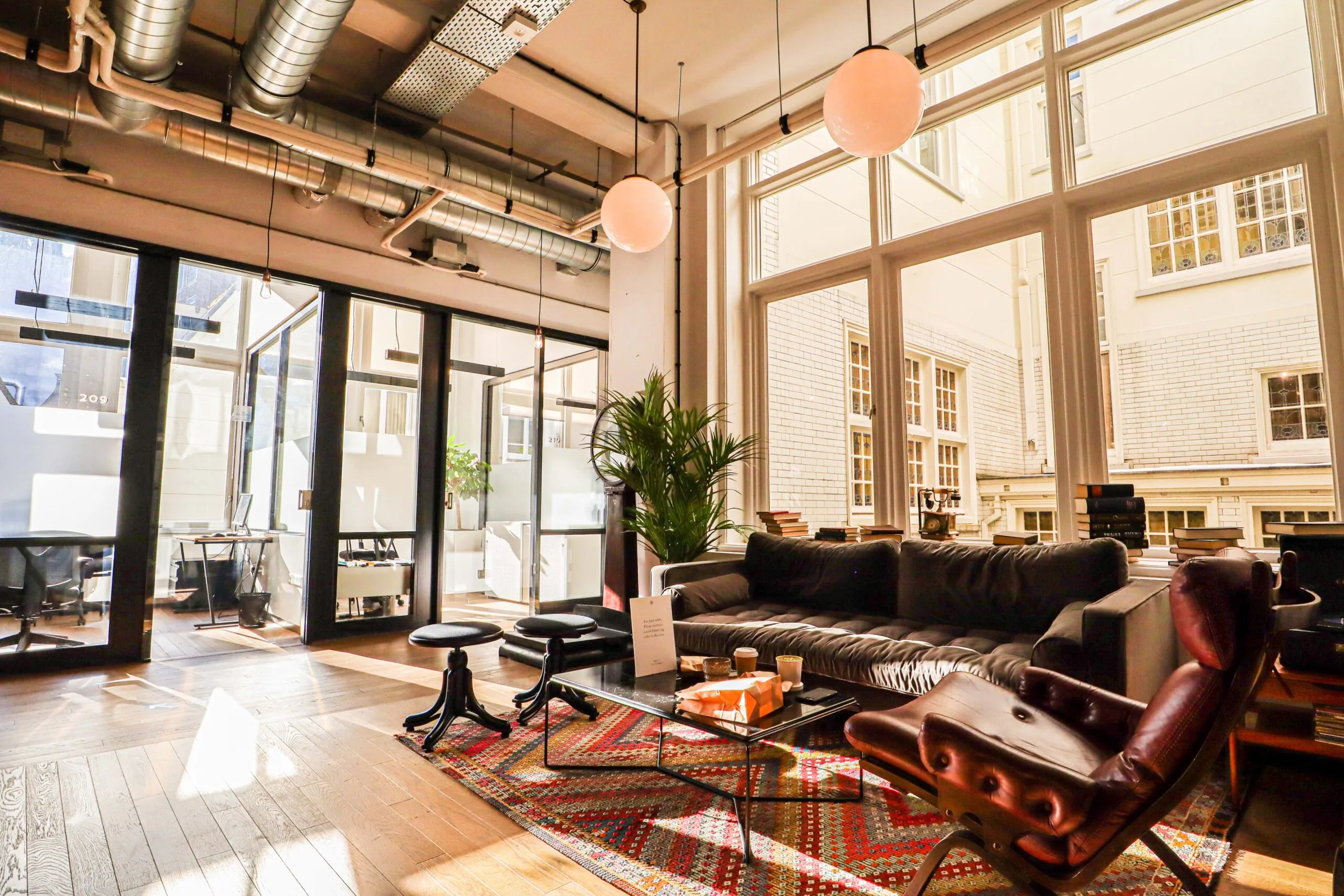 Moderne loungehoek met designmeubilair en grote ramen in kantoorruimte DAM 1.