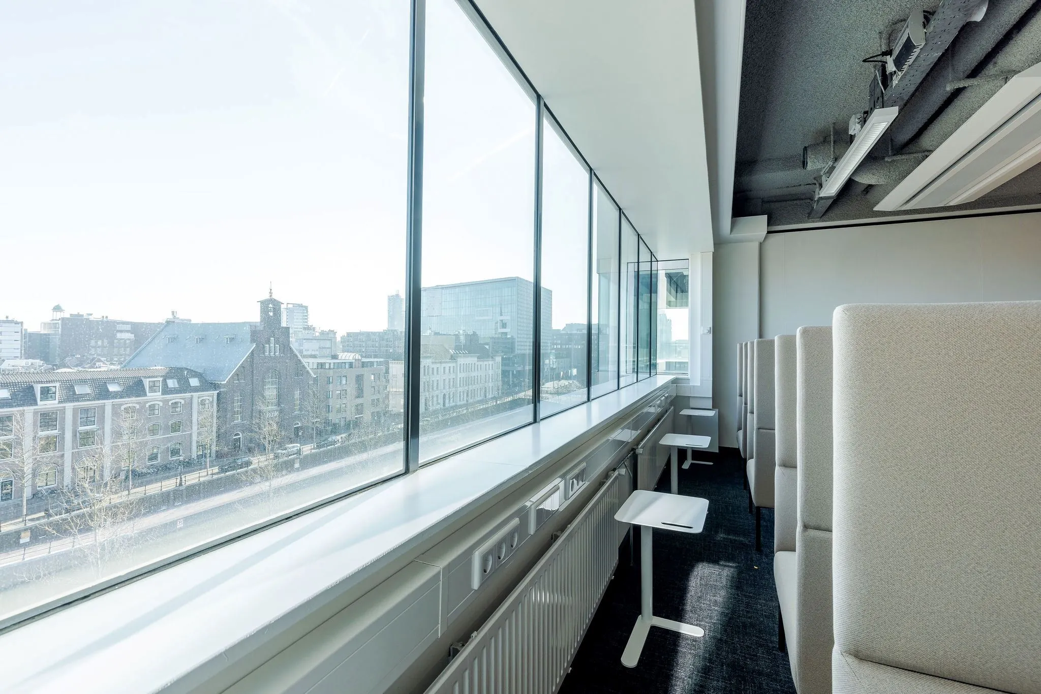 Moderne werkplekken met zitnissen en uitzicht over de Daalsesingel in Utrecht door een groot raam.