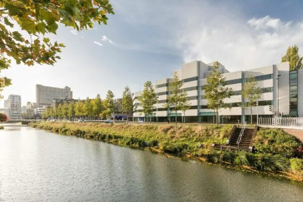 Kantoorpand aan de Daalsesingel 51 in Utrecht met bomen en water op de voorgrond.