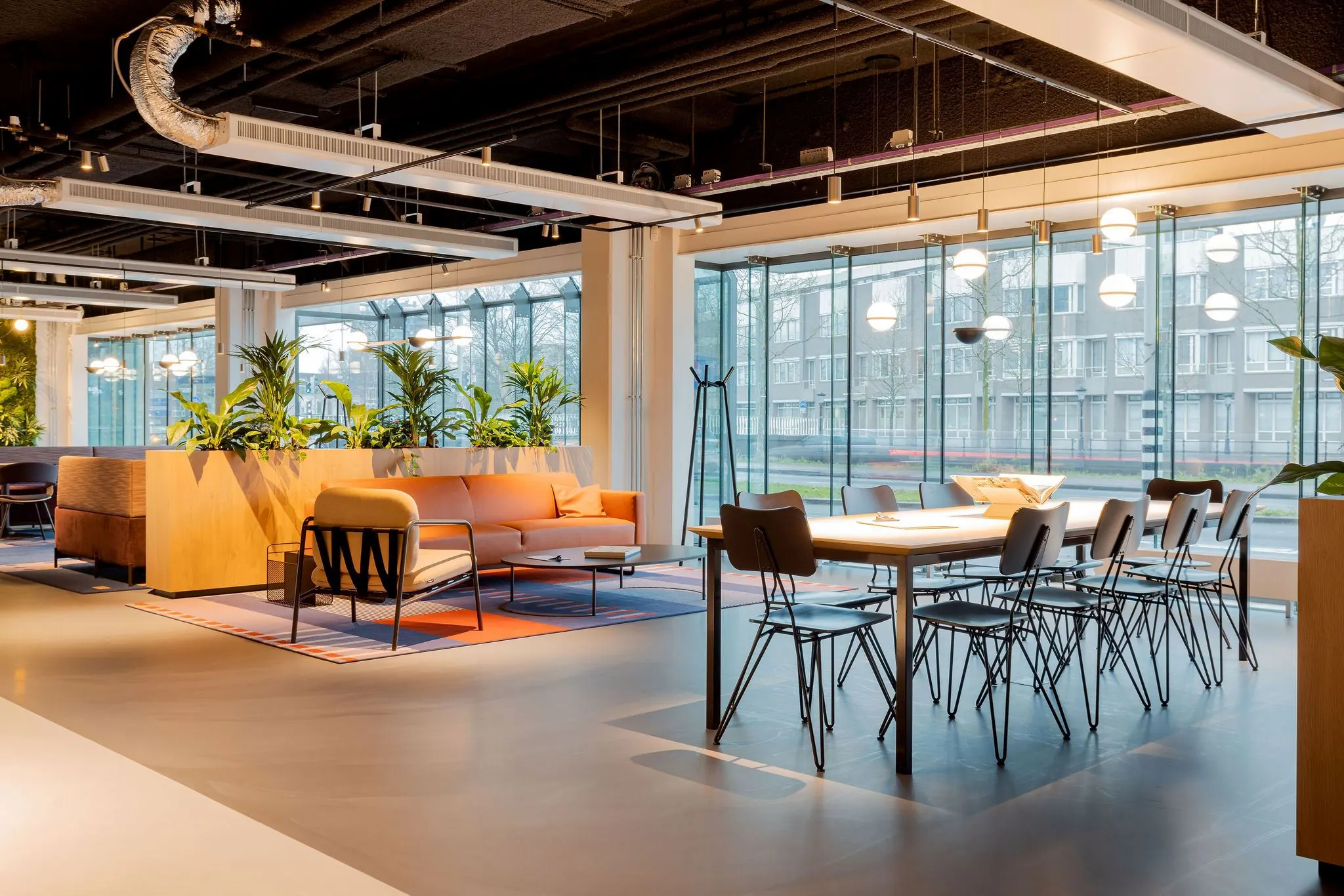 Moderne en licht ingerichte kantoorruimte aan de Daalsesingel 51 met zithoek, lange vergadertafel en grote ramen.