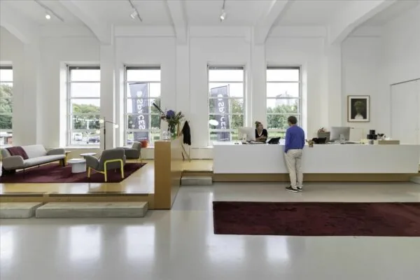 Moderne receptieruimte in De Rode Olifant met zithoek, balie en grote ramen.