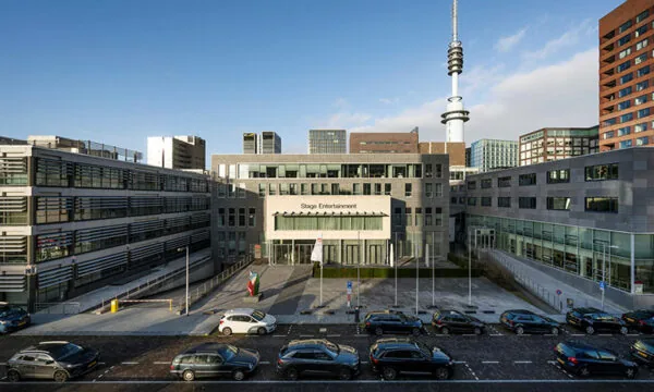 Voorgevel van het Stage Entertainment-gebouw aan de De Boelelaan 30 in Amsterdam, met geparkeerde auto's op de voorgrond.