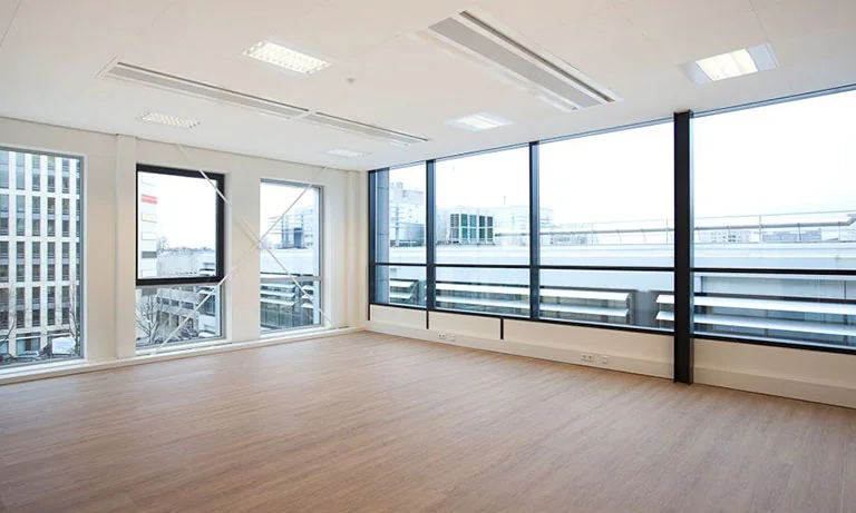 Licht en modern kantoorruimte met grote ramen aan De Boelelaan 30, met uitzicht op omliggende kantoorgebouwen.