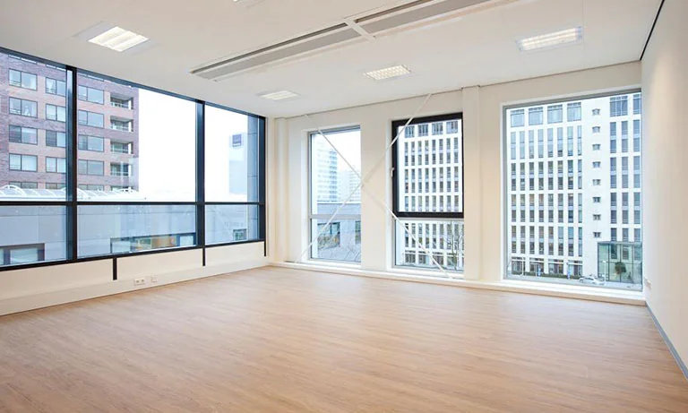 Licht en modern leeg kantoor op De Boelelaan 30 met grote ramen en uitzicht op omliggende kantoorgebouwen.