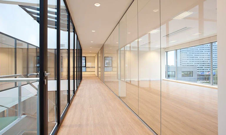 Moderne kantoorruimte aan De Boelelaan 30 met glazen wanden en houten vloer.