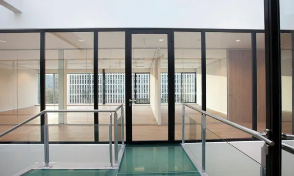 Modern kantoorinterieur aan de De Boelelaan 30 met glazen wanden en een glazen loopbrug.