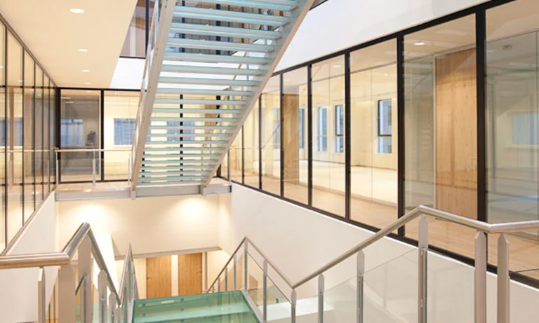 Moderne, lichte kantoorruimte op De Boelelaan 30 met glazen trappen en wanden.