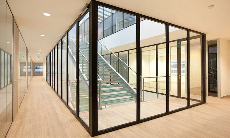 Moderne, glazen trappenhal in kantoorgebouw aan de De Boelelaan 30 met houten vloer en strakke afwerking.