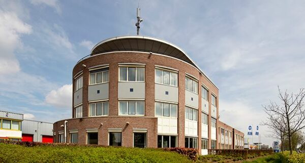 Modern kantoorgebouw aan de Dr. Nolenslaan 157 met ronde gevel en bakstenen buitenkant.