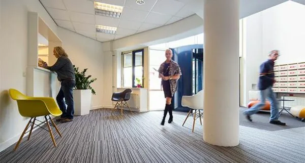 Moderne wachtruimte aan de Dr. Nolenslaan 157 met bezoekers, zitstoelen en een balie.