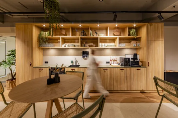 Moderne pantryruimte in EO Diemen met houten kasten, koffiehoek en ronde tafel met stoelen.