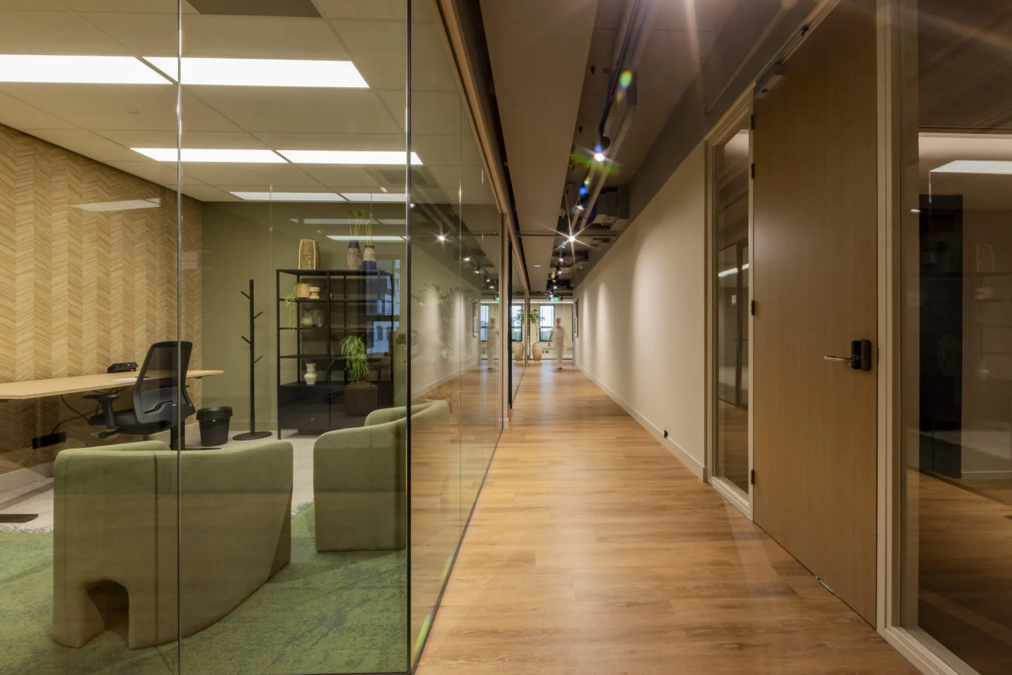 Moderne kantoorruimte in EO Diemen met glazen wanden, houten vloer en stijlvolle inrichting.