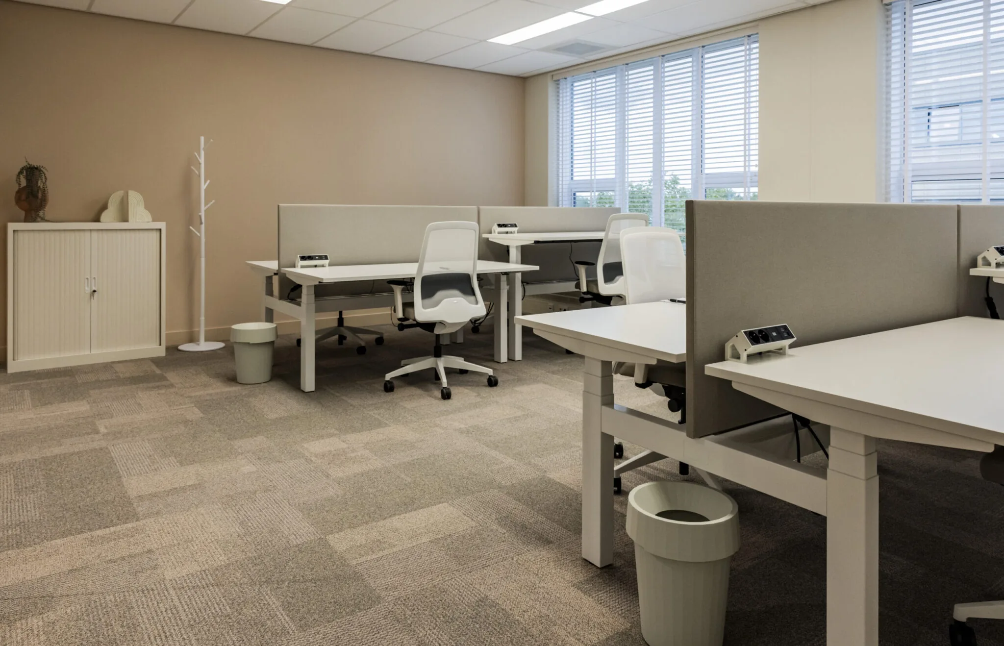Moderne en rustige kantoortuin in EO Diemen met witte bureaus, ergonomische stoelen en akoestische afscheidingen.