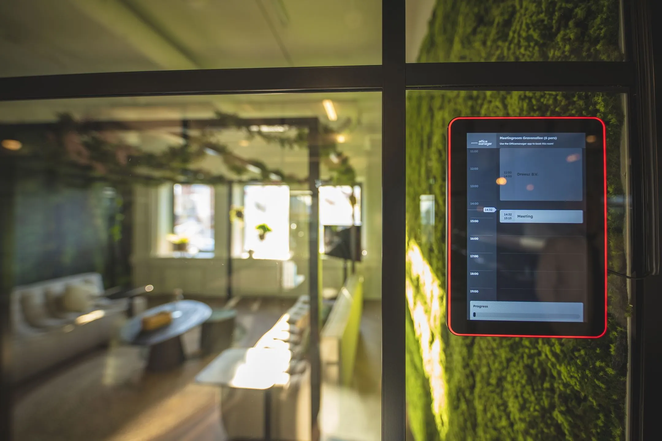 Digitale reserveringsmonitor bij vergaderruimte in modern kantoor aan de Egbert Gorterstraat 2-14.