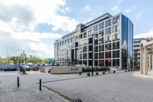 Modern kantoorgebouw aan de Euclideslaan 265 in Utrecht met glazen gevel en parkeerterrein op de voorgrond.