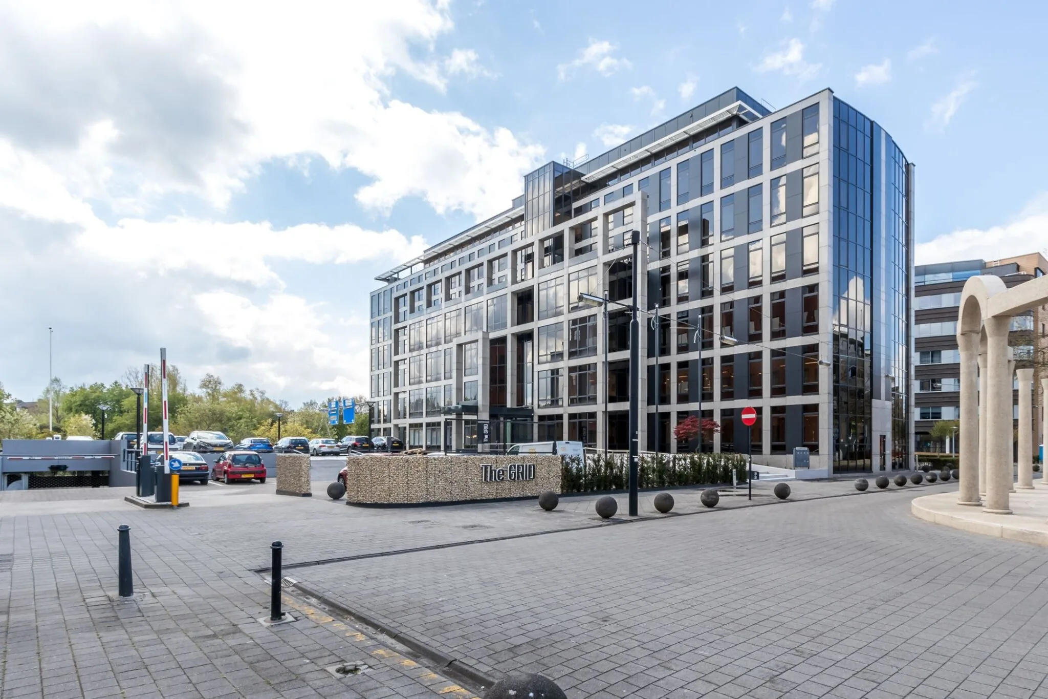 Modern kantoorgebouw aan de Euclideslaan 265 in Utrecht met glazen gevel en parkeerterrein op de voorgrond.