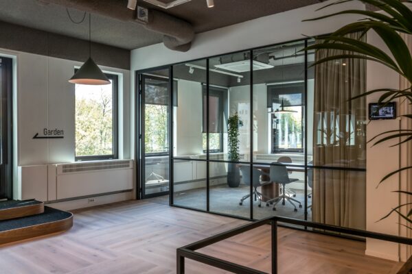 Moderne kantoorruimte aan de Euclideslaan 265 met glazen vergaderruimte en houten vloer.