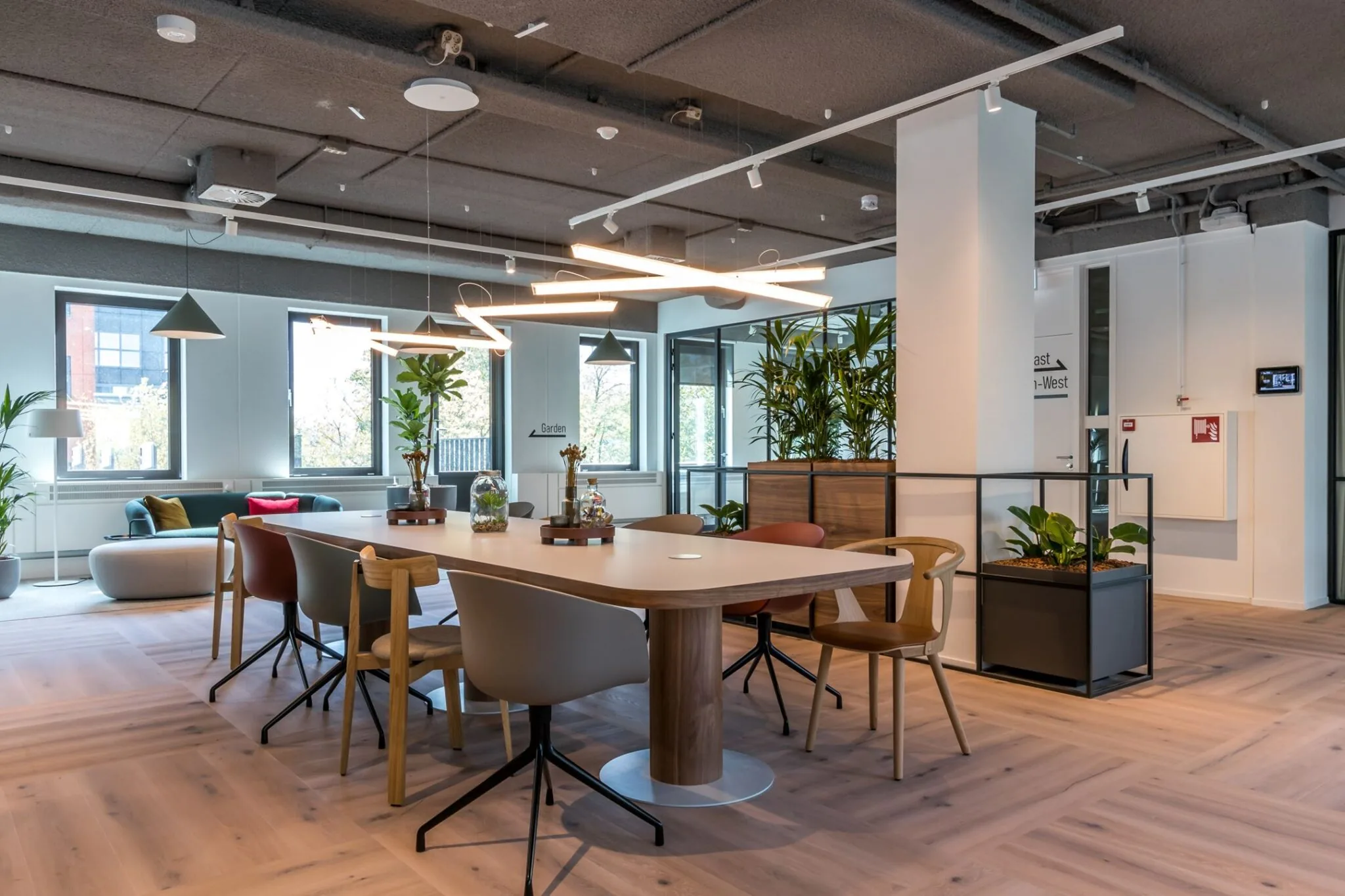 Moderne kantoorruimte aan de Euclideslaan 265 met een grote vergadertafel, designstoelen en veel groen.