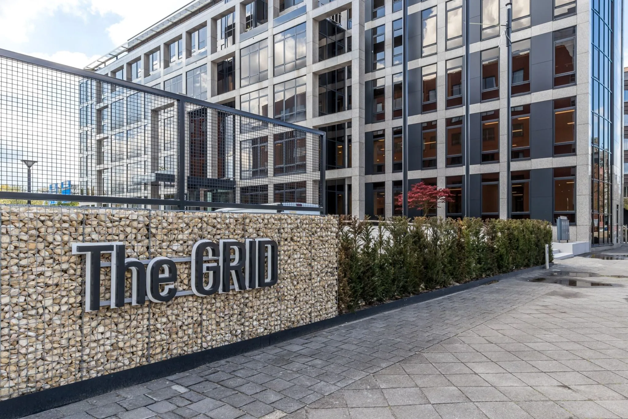 Moderne kantoorgebouw "The GRID" aan de Euclideslaan 265 met een stenen gevel en strak glazen front.