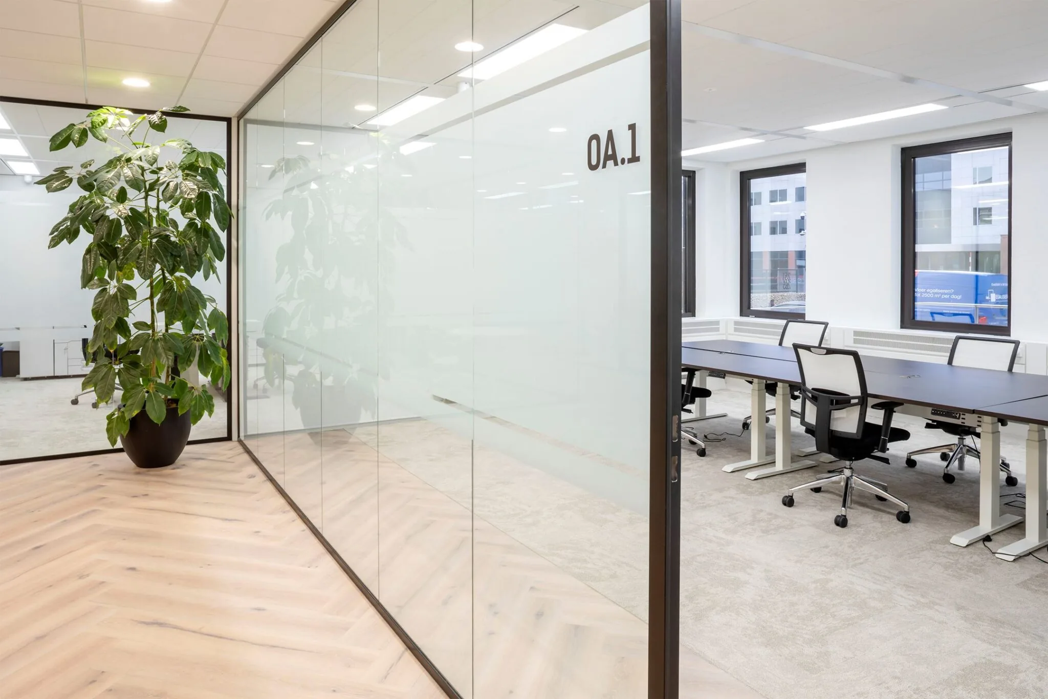 Moderne kantoorruimte aan de Euclideslaan 265 met glazen vergaderruimte, bureaus en bureaustoelen.