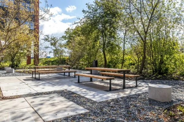 Picknickbanken op een betegeld terras in een groene buitenruimte bij Euclideslaan 265.