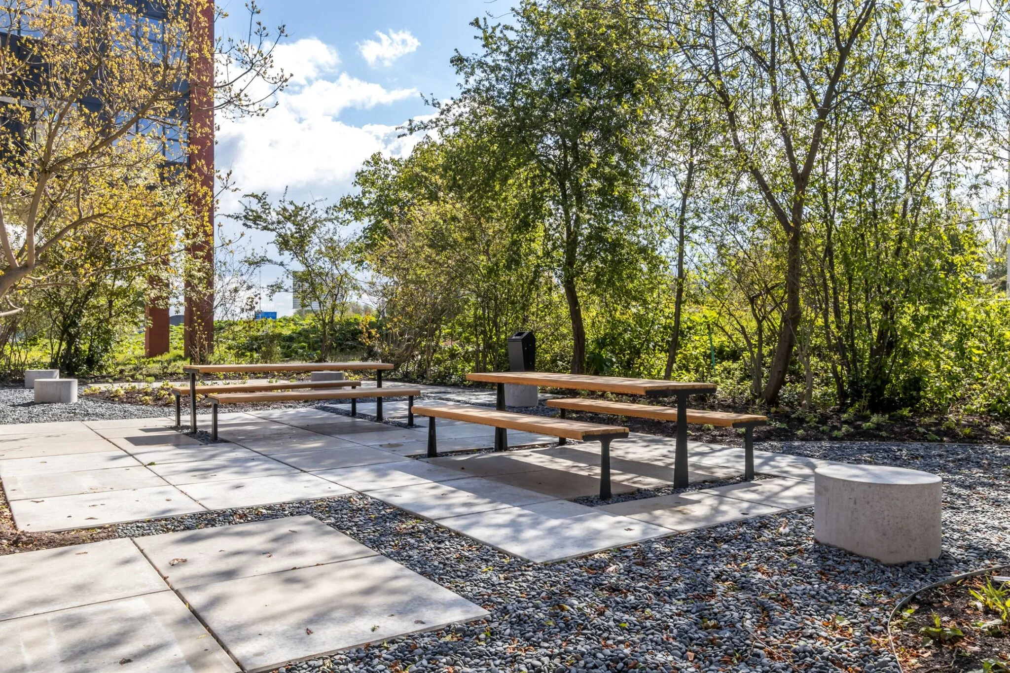 Picknickbanken op een betegeld terras in een groene buitenruimte bij Euclideslaan 265.