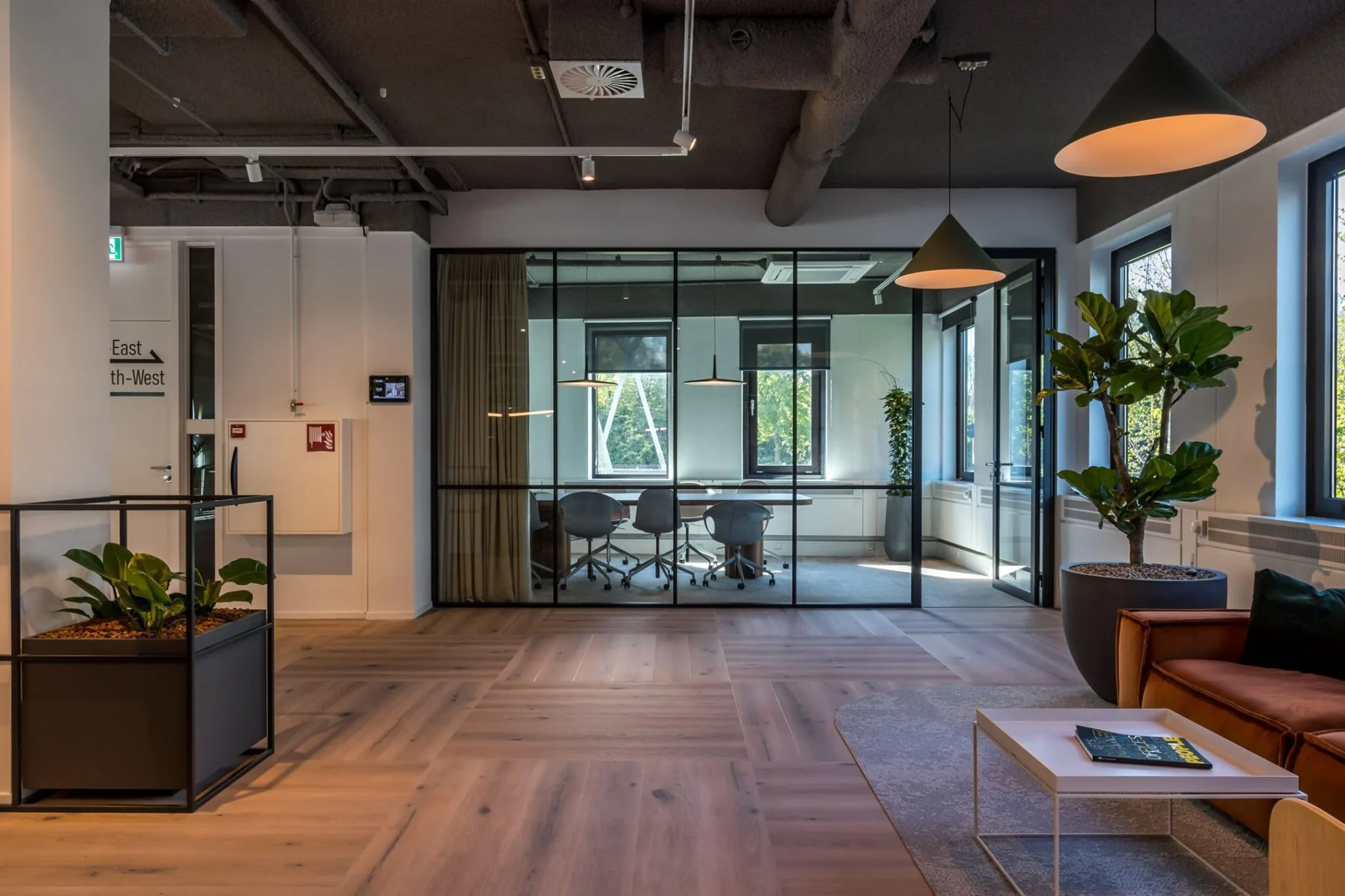Moderne kantoorruimte aan de Euclideslaan 265 met glazen vergaderruimte, houten vloer en sfeervolle inrichting.