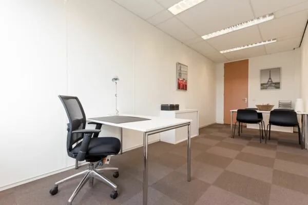 Modern ingerichte kantoorruimte met bureau, bureaustoel en vergadertafel aan de Europalaan 16.