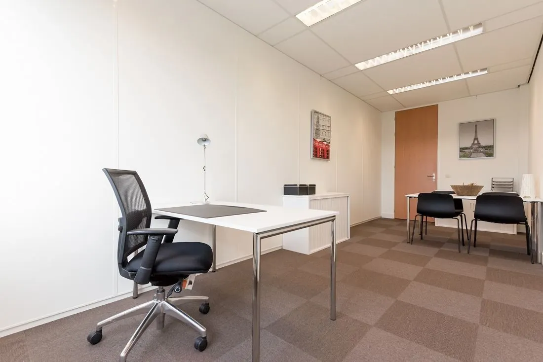 Modern ingerichte kantoorruimte met bureau, bureaustoel en vergadertafel aan de Europalaan 16.