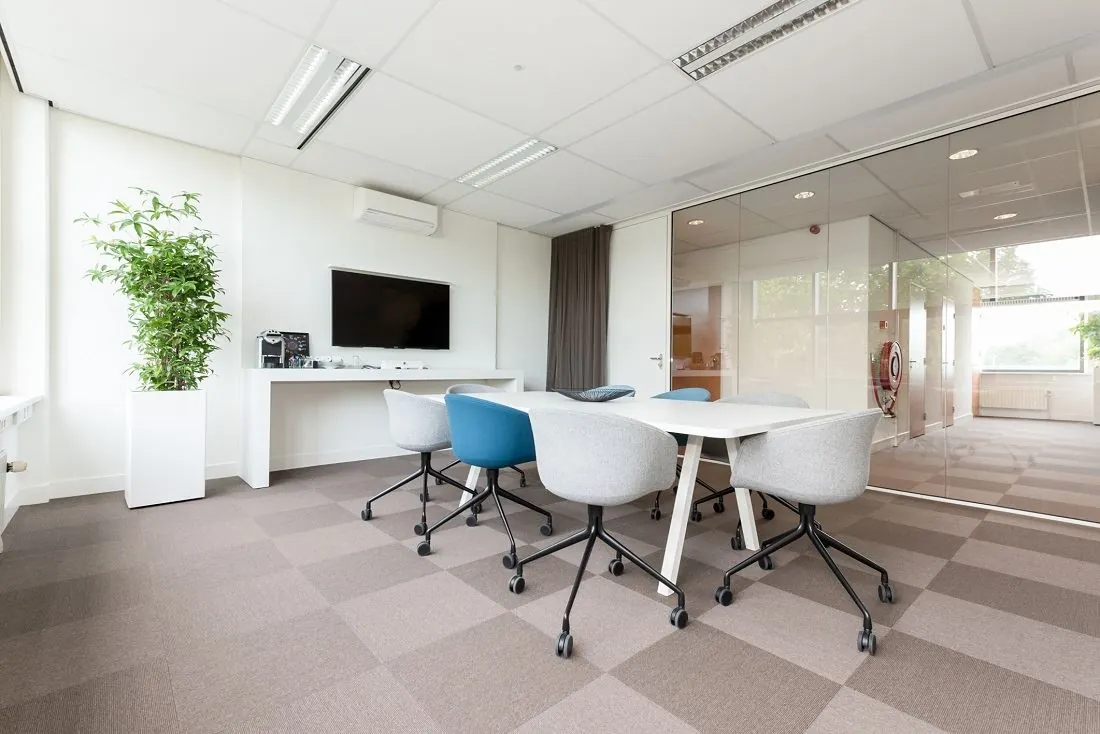 Vergaderruimte met modern meubilair, glazen wand, televisie en strakke inrichting aan de Europalaan 16.
