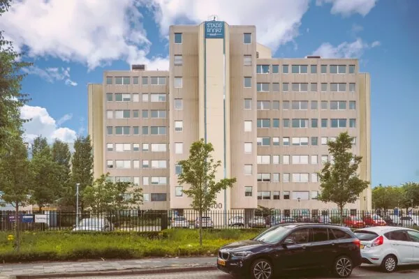 Vooraanzicht van het kantoorgebouw 'Stadsport Zuid' met geparkeerde auto's op de voorgrond.