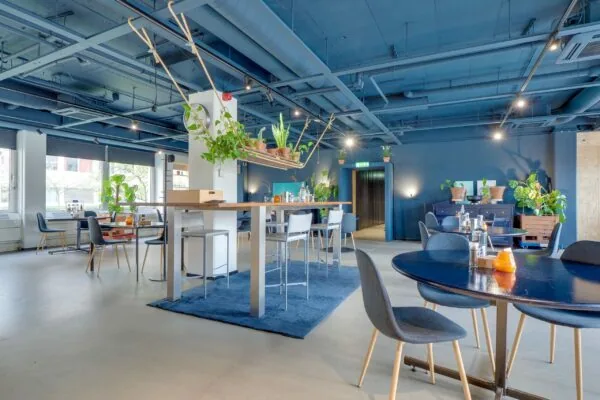 Moderne en kleurrijk ingerichte kantoorruimte aan de Europalaan 400 met blauwe accenten, planten en diverse zitgelegenheden.