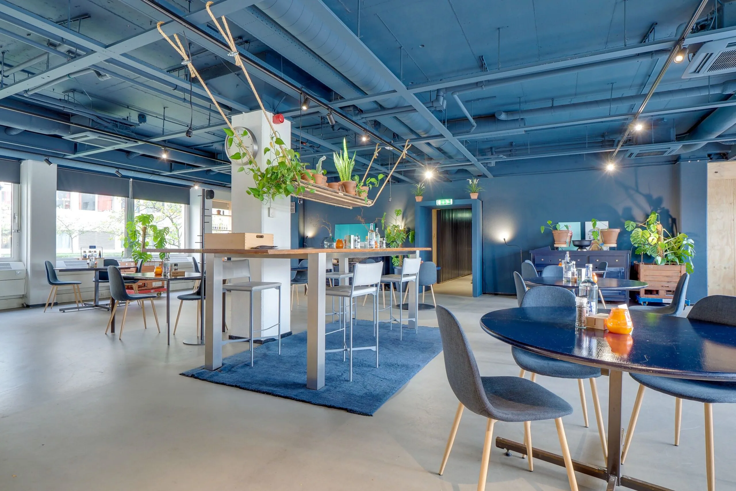 Moderne en kleurrijk ingerichte kantoorruimte aan de Europalaan 400 met blauwe accenten, planten en diverse zitgelegenheden.