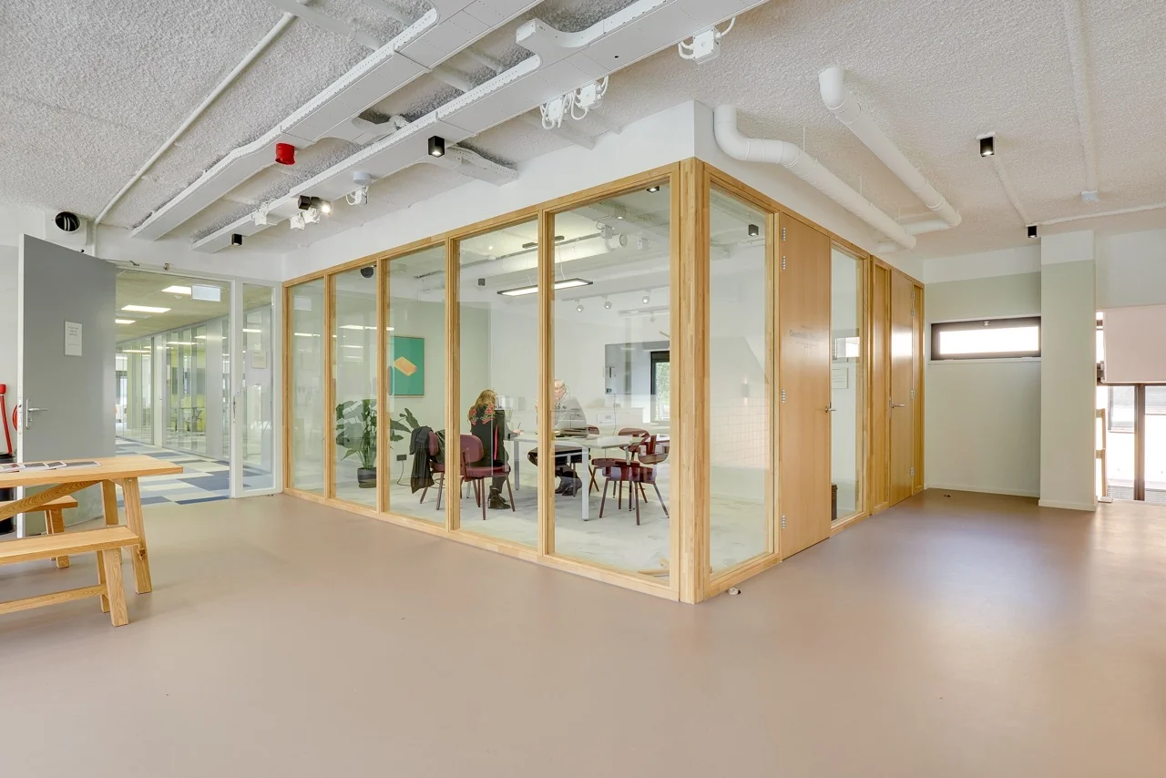 Vergaderruimte met glazen wanden en houten kozijnen in een modern kantoor aan de Europalaan 93.