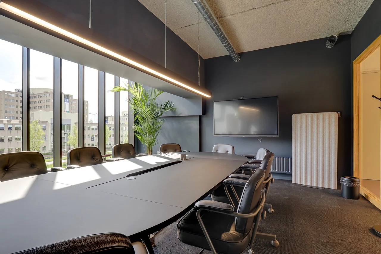 Moderne vergaderruimte met zwart interieur, grote ramen en uitzicht op kantoorgebouwen aan de Europalaan.