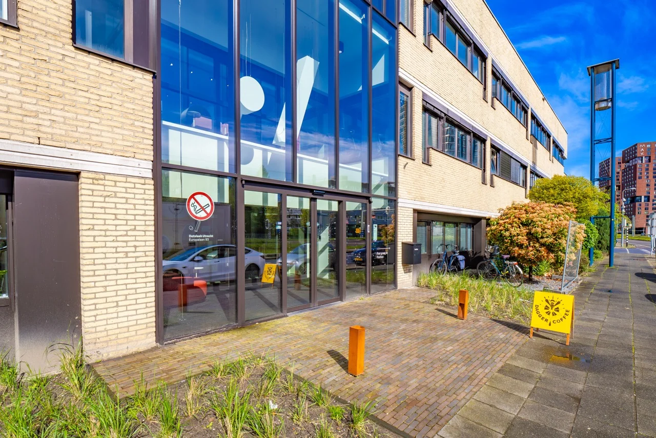 Ingang van het kantoorgebouw aan de Europalaan 93 in Utrecht met glazen gevel en een bord van Dagger Coffee op de stoep.
