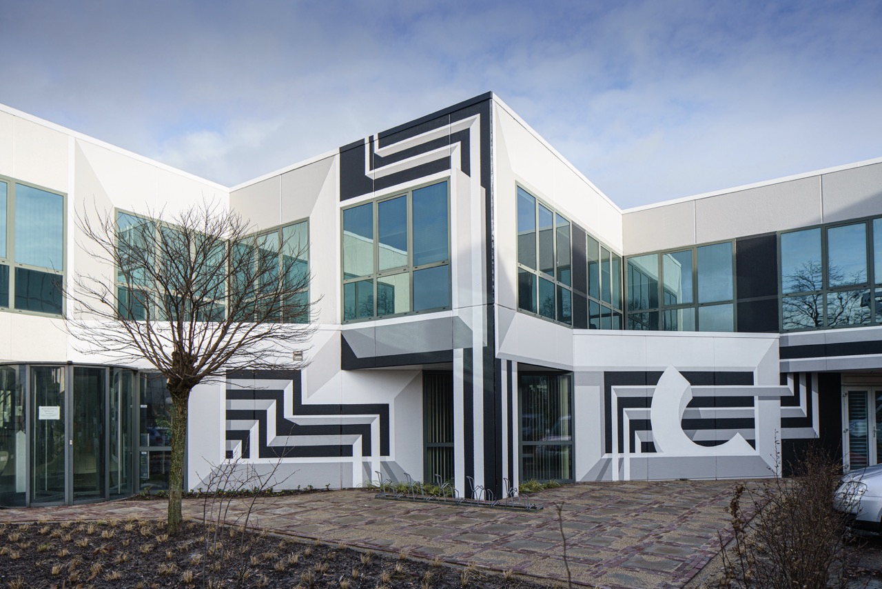 Modern kantoorgebouw met geometrische zwart-wit muurschildering en grote ramen, getiteld _FFH6789 groot.