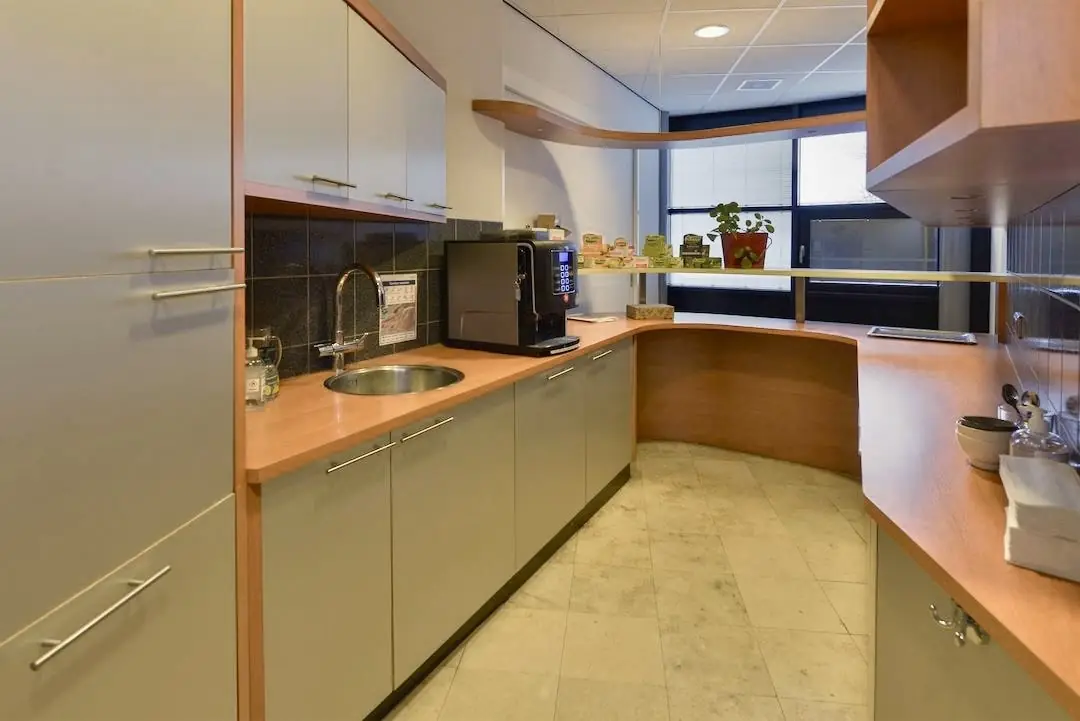 Moderne pantry met koffieautomaat en spoelbak in FlexOffiZ Amersfoort aan de Heliumweg 10.
