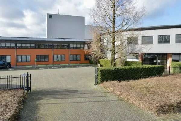 Vooraanzicht van het kantoorpand FlexOffiZ aan de Heliumweg 18 in Amersfoort met parkeerplaatsen en omringend groen.