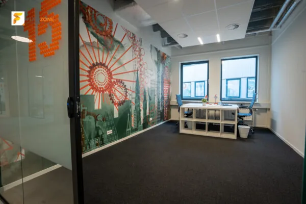 Modern ingerichte kantoorruimte in Flexizone 13 met kleurrijke muurschildering en twee werkplekken bij het raam.