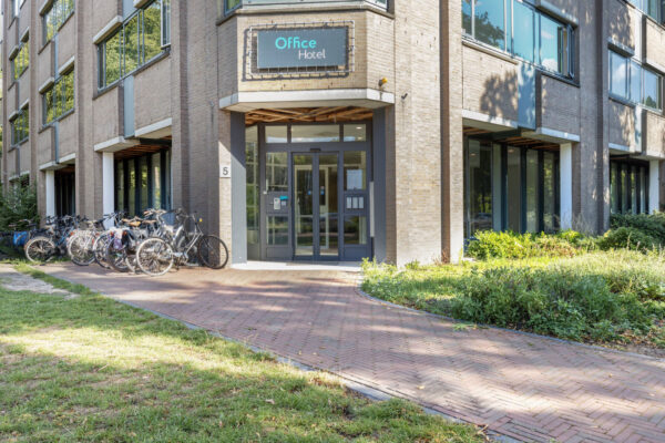 Ingang van het Office Hotel aan de Fonteinlaan 5 in Haarlem, met geparkeerde fietsen voor de deur.