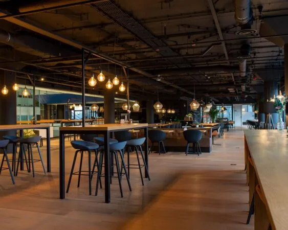 Moderne, sfeervol verlichte horeca- of werkruimte in Groningen met houten vloeren en industriële details.