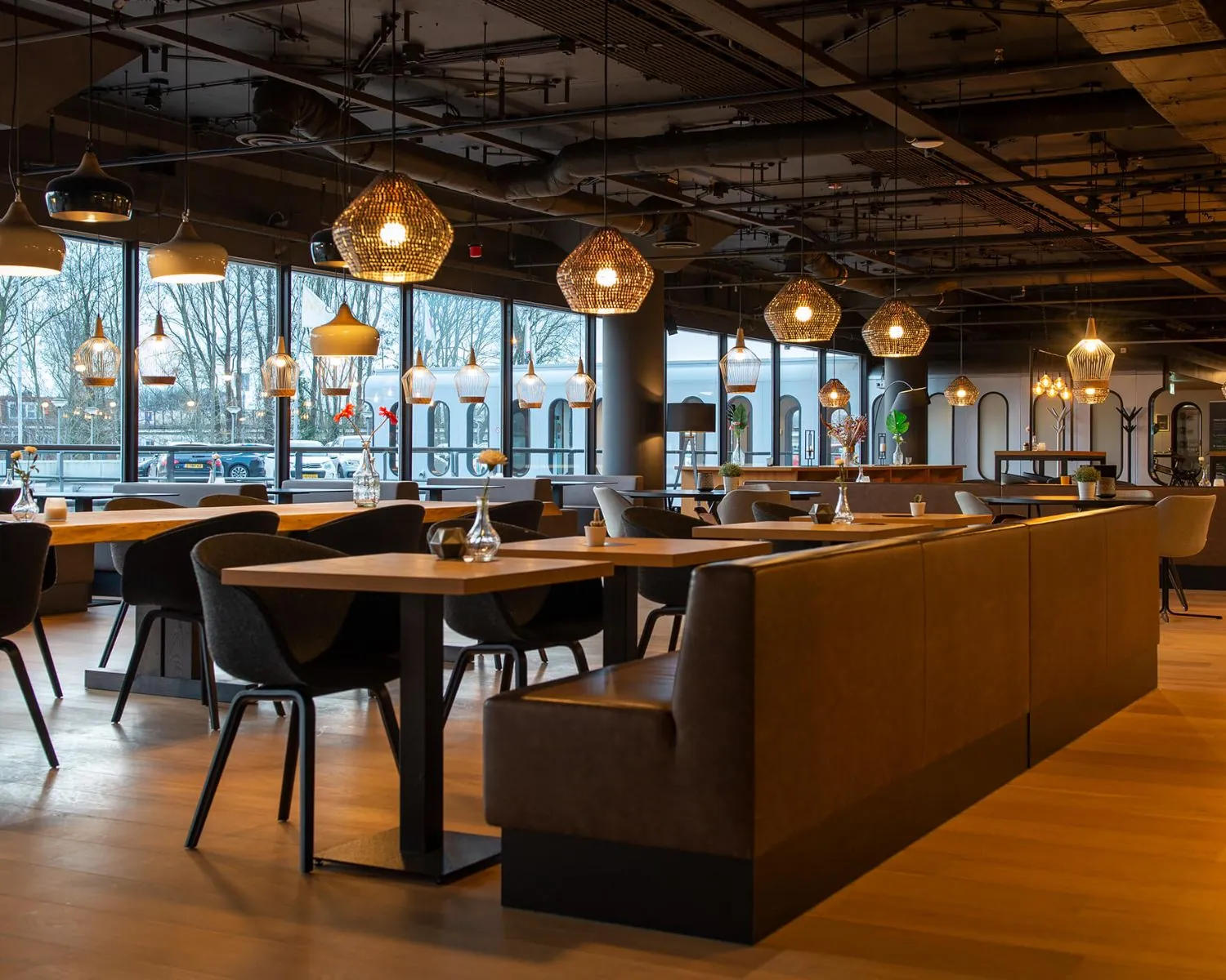 Modern ingerichte horecaruimte in Groningen met houten vloeren, stijlvolle verlichting en grote ramen met uitzicht op de straat.