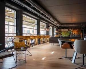 Moderne, sfeervol ingerichte horecaruimte in het Stadspark van Groningen met veel daglicht en een mix van zitplekken.